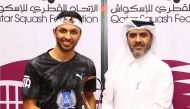 Qatar’s Abdulla Al Tamimi (left) poses with the trophy with Secretary General of the Qatar Tennis, Squash and Badminton Federation Tariq Darwish Zainal.  