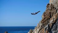 A cliff diver of La Quebrada performs after resuming activities following the passage of Hurricane Otis in Acapulco, Guerrero state, Mexico on December 8, 2023. Photo by Francisco Robles / AFP