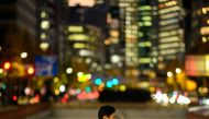 A pedestrian walks in Tokyo's Ginza district at dusk on December 13, 2023. (Photo by Philip FONG / AFP)
