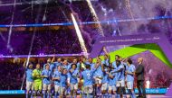 :Manchester City players celebrate with their winning trophy at the end of the FIFA Club World Cup 2023 football final match against Brazil's Fluminense at King Abdullah Sports City Stadium in Jeddah on December 22, 2023. (Photo by Giuseppe CACACE / AFP)
