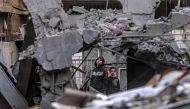 People inspect the rubble of a building destroyed by Israeli bombardment in Rafah in the southern Gaza Strip on December 24, 2023. (Photo by Said Khatib / AFP)
