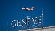 A commercial plane of low cost airline EasyJet take off behind a sign of Geneva International Airport, after dozens of ground staff went on strike over a wage dispute with their employer, the Dubai National Air Travel Agency (DNATA) delaying flights during the busy holiday season, in Geneva, on December 24, 2023. (Photo by Fabrice COFFRINI / AFP)
 