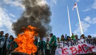 University students burn tyres as they protest against the arrival of Rohingya refugees in front of the People's Representative Council (DPR) in Banda Aceh on December 27, 2023. (Photo by Chaideer Mahyuddin / AFP)