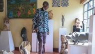 Kenyan stone sculptor Elkana Ong'esa walks surrounded by some of his sculptures at the Elkana Ong'esa Museum (ELKOM) in Kisii on November 29, 2023. (Photo by Simon Maina / AFP)