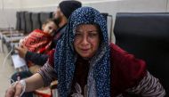 A victim of an Israeli army strike gestures as she receive treatment at Kuwait hospital in Rafah in the southern Gaza Strip on December 28, 2023. Photo by MOHAMMED ABED / AFP