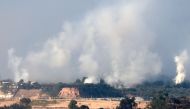 Plumes of smoke rising over Gaza City during Israeli strikes on December 31, 2023. (Photo by Menahem Kahana / AFP)