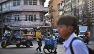 An ice cream vendor crosses an intersection in Bangkok on January 3, 2024. Photo by Lillian SUWANRUMPHA / AFP