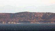 A general view shows the North Korean coastline with artillery bunkers as seen from a viewpoint on Yeonpyeong island on January 7, 2024. (Photo by Stringer / Yonhap / AFP)