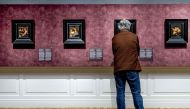 A person looks at painting during the preview of the exhibition 'Rembrandt's four senses - his first paintings' in the De Lakenhal museum in Leiden, on January 18, 2024. Photo by Remko de Waal / ANP / AFP