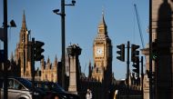 A pedestrian passes CCTV cameras a road junction on the south bank of the River Thames, as The Elizabeth Tower, commonly known by the name of the clock's bell, 