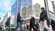 Pedestrians cross the street in front of luxury shops at the Ginza shopping district in Tokyo on January 19, 2024. Photo by Richard A. Brooks / AFP