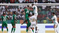 Algeria's forward #9 Baghdad Bounedjah (CR) heads the ball to score his team's second goal during the Africa Cup of Nations (CAN) 2024 group D football match between Algeria and Burkina Faso at Stade de la Paix in Bouake on January 20, 2024. (Photo by KENZO TRIBOUILLARD / AFP)
