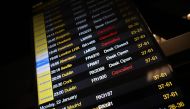 The departure board at Manchester Airport shows many flights cancelled or delayed due to high winds caused by Storm Isha on January 21, 2024. (Photo by Paul Ellis / AFP)