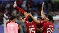 Qatar's players celebrate with their forward #10 Hassan Al-Haydos after he scored their first goal during the Qatar 2023 AFC Asian Cup Group A football match between Qatar and China at Khalifa International Stadium in Doha on January 22, 2024. (Photo by Karim Jaafar / AFP)