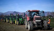 Farmers drive tractors in a field alongside the road during a demonstration near the highway in Rivoli, near Turin, on February 5, 2024. (Photo by MARCO BERTORELLO / AFP)
