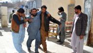 A bomb blast victim (2L) is helped to walk into a hospital in Quetta on February 7, 2024. (Photo by AFP)