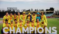 Australia players pose for a photo with the trophy after winning the under-19 World Cup youth one-day international (YODI) final between India and Australia at Willowmoore Park in Benoni on February 11, 2024. (Photo by Phill Magakoe / AFP)