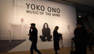 Visitors walk past a poster during a photocall to promote the forthcoming exhibition 'Yoko Ono: Music of the Mind' at Tate Modern in London on February 13, 2024. Photo by Daniel LEAL / AFP