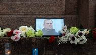 A portrait of Alexei Navalny, candles and flowers are left at a memorial in Paris on February 16, 2024, after the announcement that the Kremlin's most prominent critic had died in an Arctic prison. (Photo by Ian LANGSDON / AFP)
