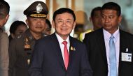 (Files) Former Thai Prime Minister Thaksin Shinawatra (C) arrives to greet his supporters after landing at Don Mueang Airport in Bangkok on August 22, 2023. (Photo by Lillian Suwanrumpha / AFP)

