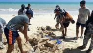 This handout photo taken on February 14, 2024 and released on February 19 by the Philippine Coast Guard (PCG) shows coast guard personnel gathering seized giant clam shells on a beach at a village in Bugsuk island, Palawan province. Photo by Handout / Philippine Coast Guard (PCG) / AFP