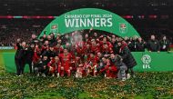 Liverpool players pose with the trophy after the English League Cup final football match between Chelsea and Liverpool at Wembley stadium, in London, on February 25, 2024. (Photo by Glyn Kirk / AFP)