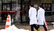 Medical workers walk outside a hospital after snowfall in Seoul on February 22, 2024. Photo by ANTHONY WALLACE / AFP