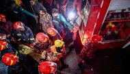 Firefighters carry an injured person during rescue operations following a fire in a commercial building that killed at least 43 people, in Dhaka, on February 29, 2024. (Photo by Munir Uz Zaman / AFP)