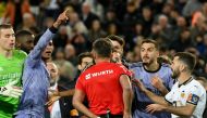 Spanish referee Jesus Gil Manzano (back) talks with Real Madrid's English midfielder #5 Jude Bellingham (C,L) during the Spanish league football match between Valencia CF and Real Madrid at the Mestalla stadium in Valencia on March 2, 2024 (Photo by JOSE JORDAN / AFP)
