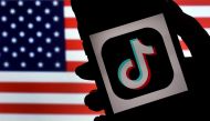 In this photo illustration, the social media application logo, TikTok is displayed on the screen of an iPhone on an American flag background on August 3, 2020 in Arlington, Virginia. Photo by Olivier DOULIERY / AFP
