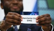 Former Nigerian footballer John Obi Mikel holds the paper slip of Manchester City during the 2023-2024 UEFA Champions League football tournament quarter-finals and semi-finals draw at the House of European Football in Nyon, on March 15, 2024. (Photo by Fabrice COFFRINI / AFP)