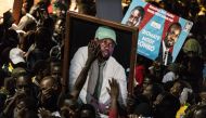 Supporters of Senegalese opposition leader Ousmane Sonko and presidential candidate Bassirou Diomaye Faye celebrate after the two men were released from prison, in Dakar on March 14, 2024. (Photo by JOHN WESSELS / AFP)
