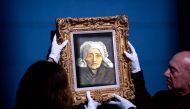 Staff members hang a rare Vincent van Gogh painting, “Tete de paysanne a la coiffe blanche”, painted circa 1884, at the TEFAF Maastricht art fair. (AFP)