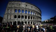 Competitors run by the Colosseum, during the Rome Marathon in Rome, on March 17, 2024. (Photo by Filippo MONTEFORTE / AFP)