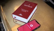 A photograph taken at the Vaudeville brasserie in Paris on March 14, 2024, shows the digital and the printed versions of the 2024 Michelin Guides. Photo by ALAIN JOCARD / AFP