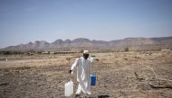 A Sudanese refugee walks back from collecting water in the newly established Awulala refugee camp, near Maganan, 80 km from the Sudanese border in Ethiopia's Amhara region, on February 28, 2024.  (Photo by Michele Spatari / AFP)
