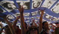 Hundreds hold a large banner with portraits of people who disappeared during the military dictatorship (1976-1983) while heading to Plaza de Mayo Square to commemorate the 48th anniversary of the coup in Buenos Aires on March 24, 2023. (Photo by Luis ROBAYO / AFP)
