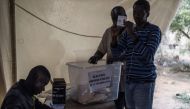 A polling station official shows a ballot to party assessors ballots at the start of the counting proceedings in Dakar, on March 24, 2024. (Photo by MARCO LONGARI / AFP)
