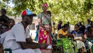 Members of a family gather under a tree while waiting to receive the remains of several family members who were victims of a Kenyan starvation cult at the Malindi Sub-County Hospital Mortuary in Malindi on March 26, 2024. (Photo by Luis Tato / AFP)
