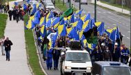 Bosnian coal miners wave Bosnian flags as they march towards government building in Sarajevo, on March 27, 2024, to protest against the deterioration of their working conditions. (Photo by ELVIS BARUKCIC / AFP)
