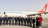 Libyan and Turkish officials pose in front of a Turkish Airlines air plane, following its first landing after a near 10-year hiatus, at the Mitiga International Airport in Tripoli on March 28, 2024. (Photo by Mahmud Turkia / AFP)