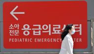 A medical worker walks past a sign for a pediatric emergency centre outside a hospital in Seoul on April 1, 2024. (Photo by Jung Yeon-je / AFP)
