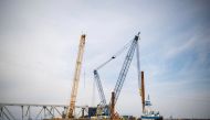 This handout photo obtained from the US Coast Guard on March 31, 2024 shows barge cranes near the collapsed Francis Scott Key Bridge on in the Patapsco River, in Baltimore, Maryland, March 30, 2024. (Photo by Taylor BACON / US COAST GUARD / AFP)
