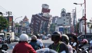Local residents ride past a damage of building caused by the earthquake in Hualien on April 4, 2024. Photo by Sam Yeh / AFP