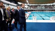 French President Emmanuel Macron, surrounded by Tony Estanguet, president of the Paris 2024 Olympics Organising Committee, Ile-de-France's Regional Council President Valerie Pecresse, Grand Paris' Metropole President Patrick Ollier and officials, visits the Olympic aquatics centre (CAO), a multifunctional venue for the Paris 2024 Olympics, on the day of its inauguration in Saint-Denis, outside Paris, on April 4, 2024. (Photo by Gonzalo Fuentes / POOL / AFP)