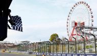A race official waves the chequered flag as Red Bull Racing's Dutch driver Max Verstappen wins the Formula One Japanese Grand Prix race at the Suzuka circuit in Suzuka, Mie prefecture on April 7, 2024. (Photo by KIM Kyung-Hoon / POOL / AFP)