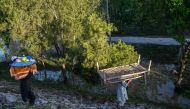 A displaced family carry their belongings to tents at a makeshift camp after fleeing from their flood hit homes following heavy rains in Charsadda district of Khyber Pakhtunkhwa province on April 17, 2024. (Photo by Abdul MAJEED / AFP)
