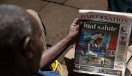 A man looks at a newspaper with the headline of the death of defence chief General Francis Omondi Ogolla and nine other senior military officers who were killed in a helicopter crash, in Nairobi on April 19, 2024. Photo by SIMON MAINA / AFP