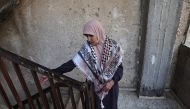 Amina Ghannam looks on as she wears a Keffiyeh stained in the blood of two of her sons who were killed in a raid by Israeli forces in the Nur Shams camp for Palestinian refugees in the occupied west bank on April 21, 2024.(Photo by Zain JAAFAR / AFP)
