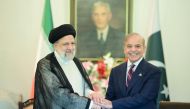 This handout photograph taken on April 22, 2024, and released by Pakistan's Press Information Department (PID) shows Iran痴 President Ebrahim Raisi (L) shakes hands with Pakistan's Prime Minister Shehbaz Sharif upon his arrival at the Prime Minister House in Islamabad. (Photo by Pakistan Press Information Department (PID) / AFP)

